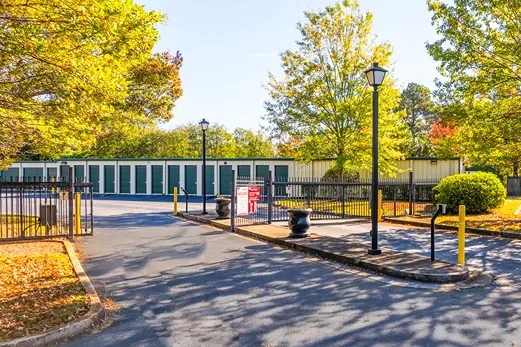 Secure gated self storage entrance with keypad access and landscaped surroundings